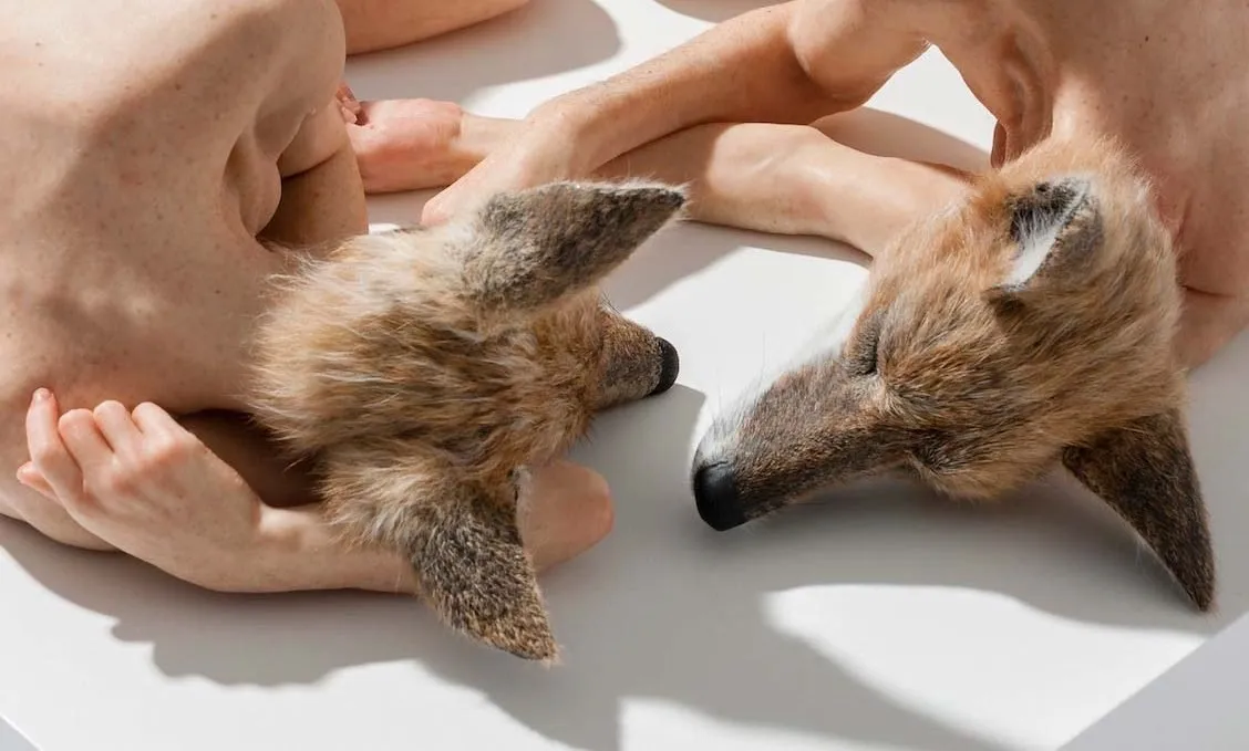 Escultura hiperrealista de una cabeza de perro sobre cuerpo humano, de Sam Jinks