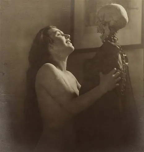 Fotografía erótica de época: mujer en éxtasis junto a un esqueleto