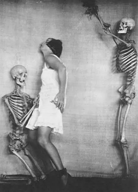Fotografía erótica de época: mujer entre dos esqueletos