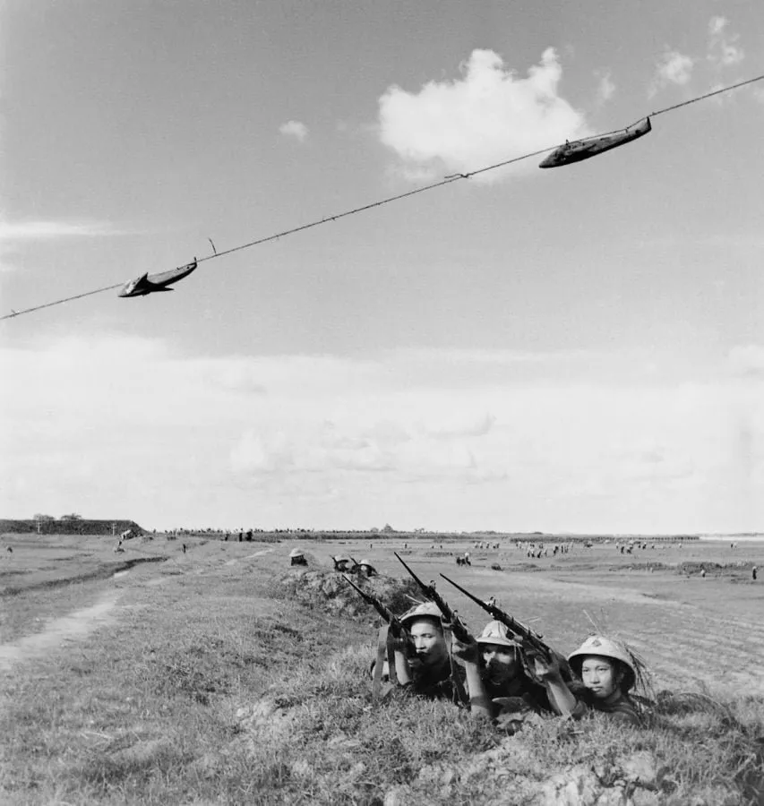 Milicianos vietnamitas entrenando el tiro antiaéreo con dianas en forma de avión, fotografía de Minh Dao (1965)