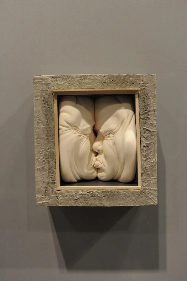 Escultura «House for Two» de Johnson Tsang, dos rostros besándose enmarcados