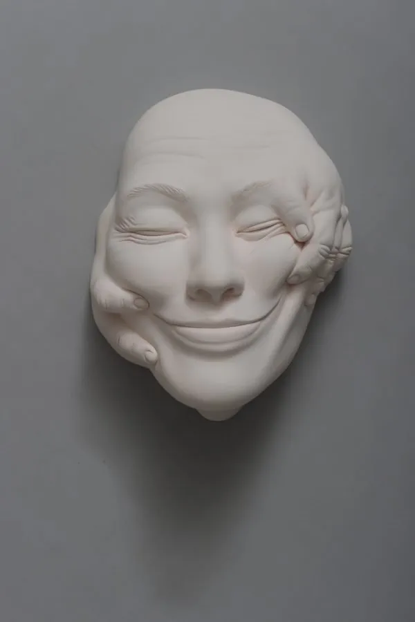 Rostro de la serie «Lucid Dream» de Johnson Tsang, envuelto como un fardo y sostenido por una mano