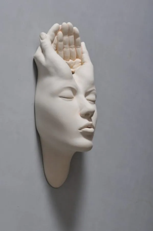 Rostro de la serie «Open Mind» de Johnson Tsang, con una mano fundida en la parte superior de la cabeza