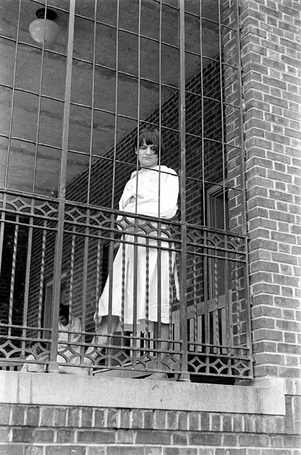 Paciente tras los barrotes de un porche enrejado del Hospital Pilgrim State (Alfred Eisenstaedt, 1938)