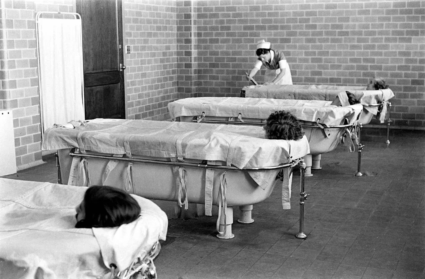 Pacientes envueltos en sábanas húmedas durante una hidroterapia en el Hospital Pilgrim State (Alfred Eisenstaedt, 1938)