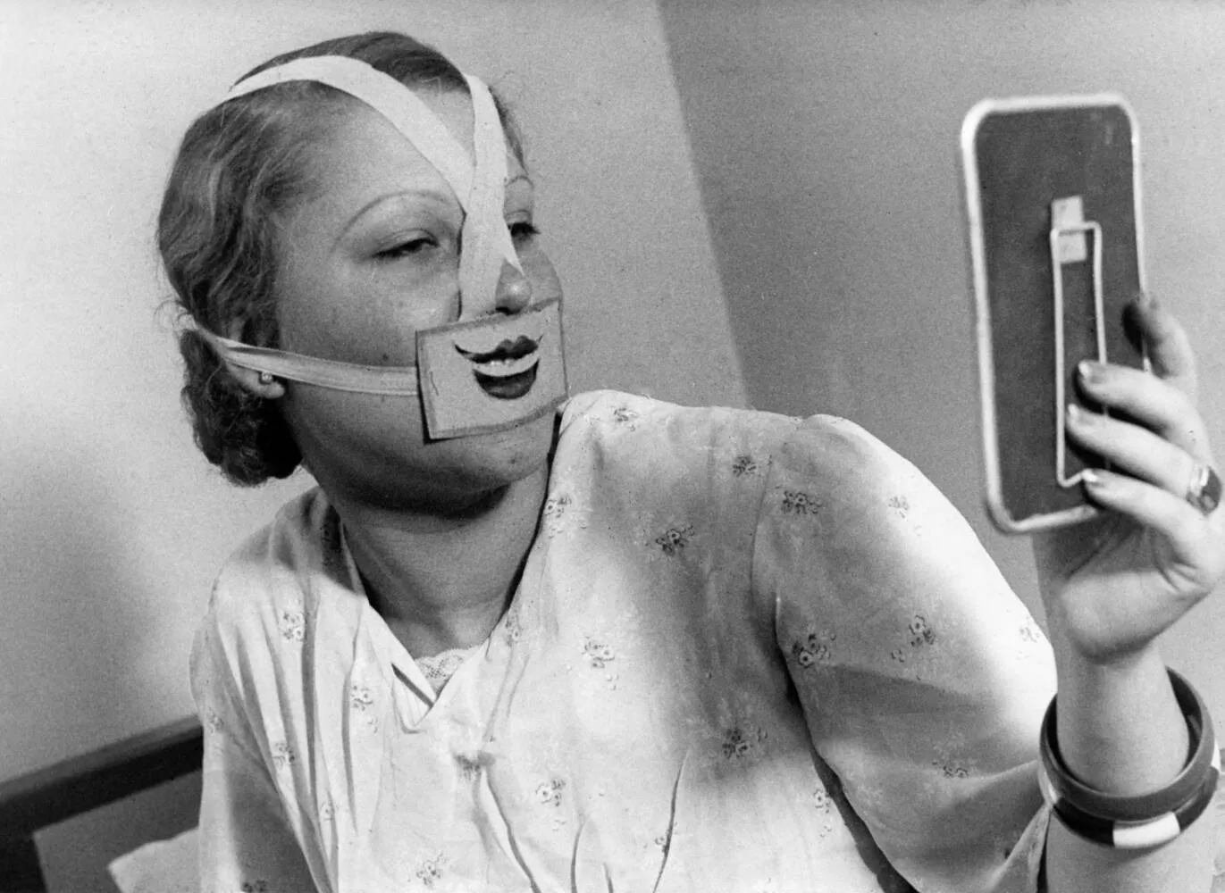 Mujer con máscara de sonrisa de cartón en la escuela de la sonrisa de Budapest, 1937. Fotografía de Het Leven (Fotobureau desconocido / Spaarnestad Photo), Nationaal Archief (Países Bajos), dominio público